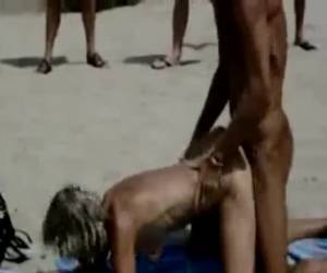 Voor over gebukt neukt hij de oude teef hard, terwijl het nudisten publiek toe kijkt.