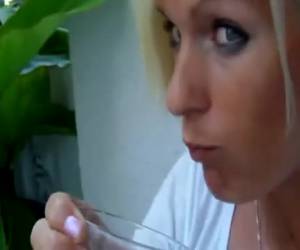 Met haar kaal geschoren kut plast ze in een glas en drinkt hem tot de laatste druppel leeg.