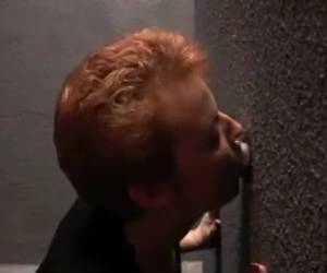 Drie piemels steken door de gaten waar de rijpe amateur snol meteen begint te zuigen. Uit de gloryhole muur steken steeds op een andere plek fallussen tevoorschijn om te pijpen.