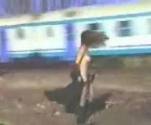 Ze staat naast het spoor met haar lange jas aan. Ineens gooit ze haar jas open en draait ze om als er een trein voorbij komt geraasd. De reizigers van die bewuste trein kunnen genieten van haar naakte lichaam.